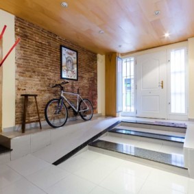 Bicycle near the brick wall in the hallway