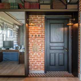 Black door with panels in a loft style hallway