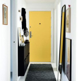 Yellow door at the end of a narrow corridor