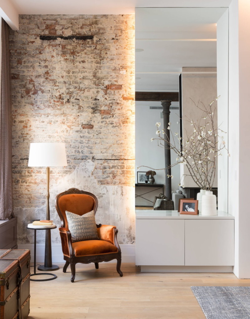 A comfortable chair in the hallway with brickwork