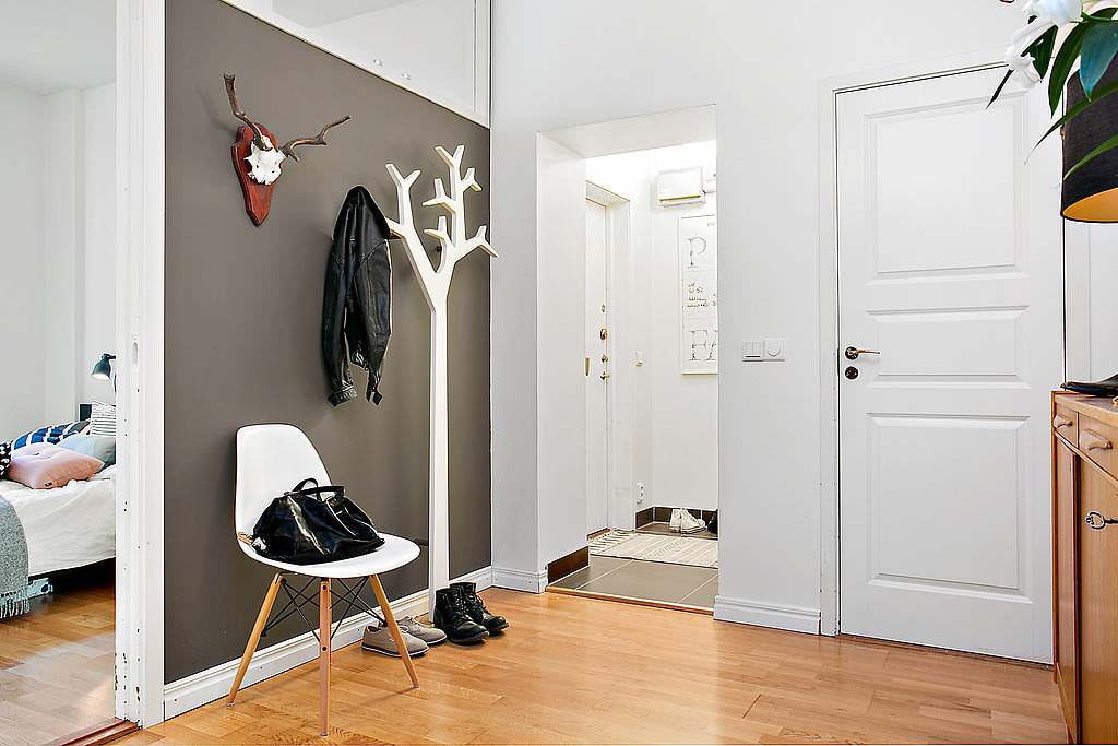 White coat hanger in the hallway against a gray wall