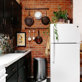 Casseroles sur le mur de briques de la cuisine