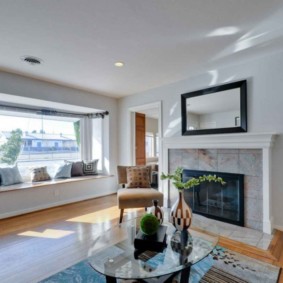 Rectangular mirror above the fireplace in the living room