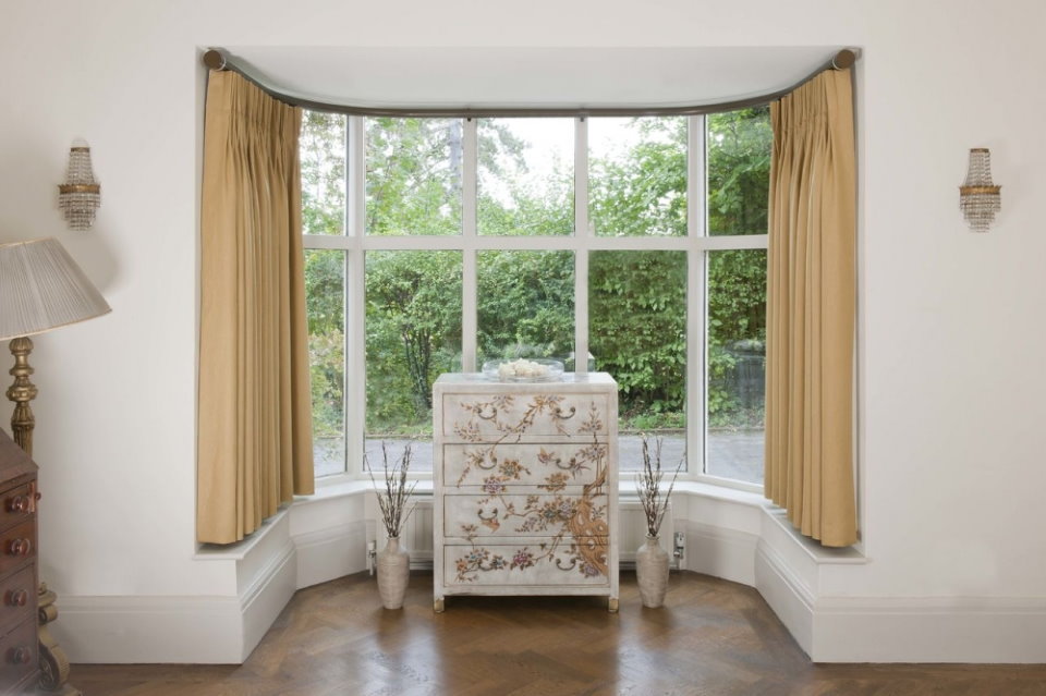 Outdoor vases in a bay window with garden views