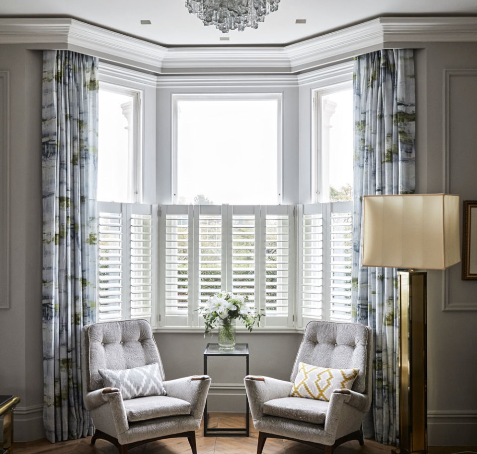 Soft chairs in the apartment with a bay window in the living room