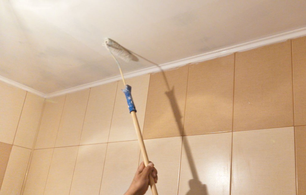 Peignez le plafond avec un rouleau dans la salle de bain