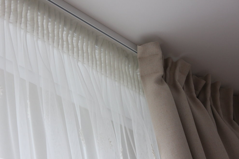 Fixation de tulle sur une corniche en aluminium sous le plafond du salon