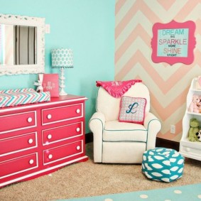 Pink chest of drawers near a white armchair