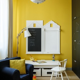 Tableau noir sur un mur jaune