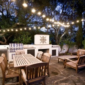 Garlands with bulbs over garden furniture