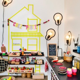 Drawing of a house with yellow paint on a white wall