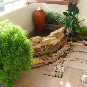 Winter garden with a pond on the balcony of the apartment