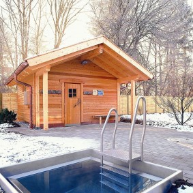 Piscine devant une baignoire en bois dans un chalet d'été