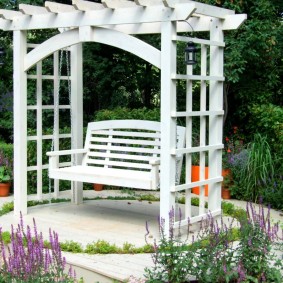 Pergola blanche avec balançoire en bois