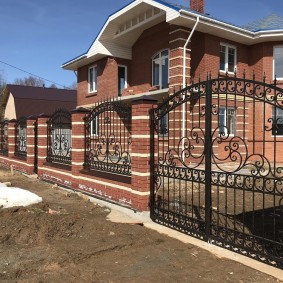 Forged gates on brick poles