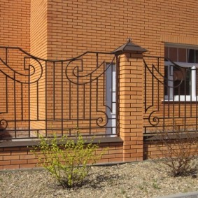 Fence of the site with a fence with brick columns