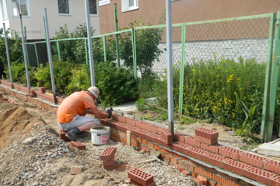 Masonry fence base with brick pillars