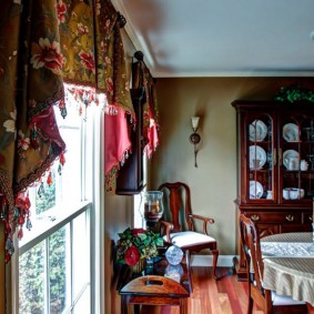 Bright lambrequin on the window in the hall of the rural house