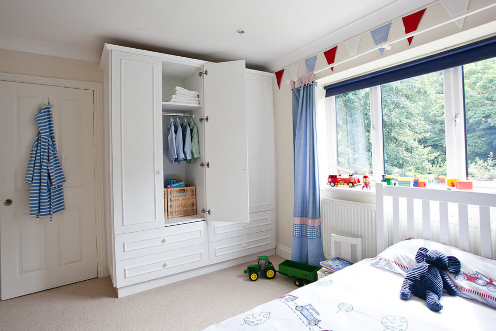 Armoire blanche avec une porte ouverte dans une chambre de garçon