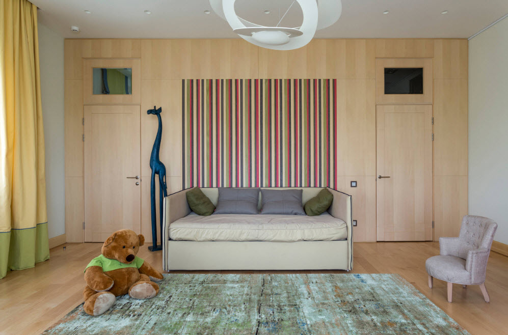 Striped wallpaper over the sofa in the nursery