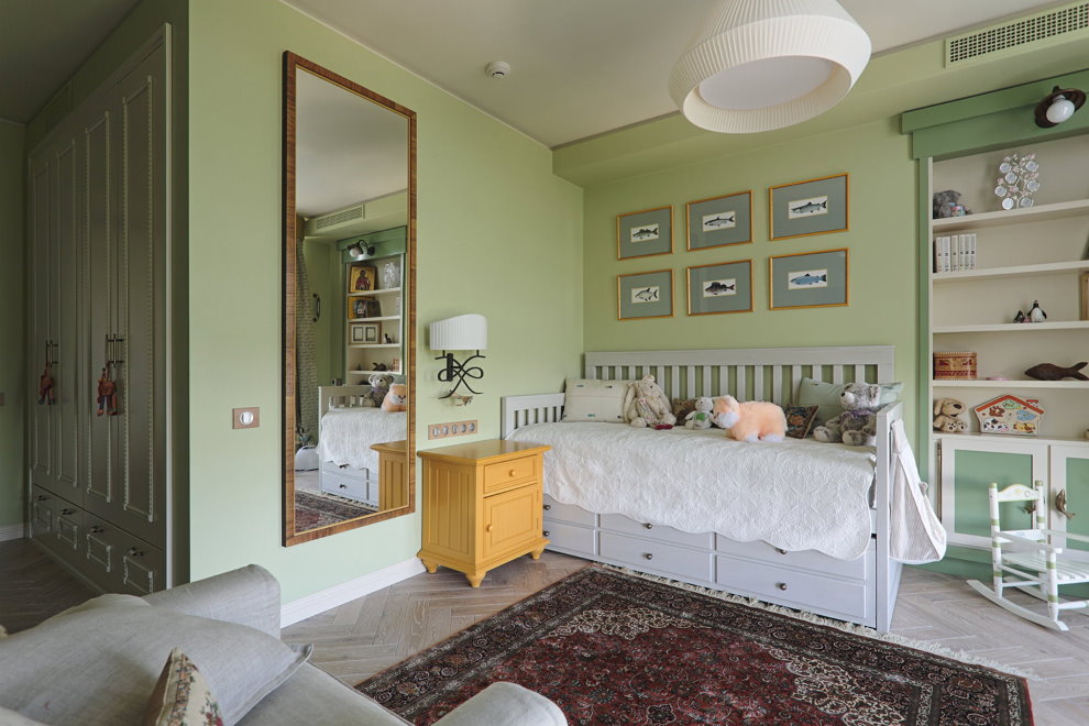 Un grand miroir sur le mur vert de la chambre des enfants