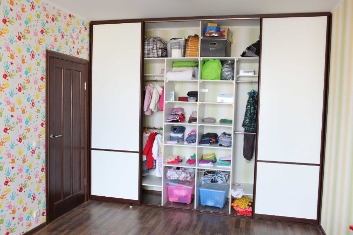 Baskets of different colors in the lower section of the wardrobe