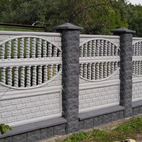 White concrete fence sections on gray pillars