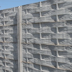 Reinforced concrete fence under a wooden wicker