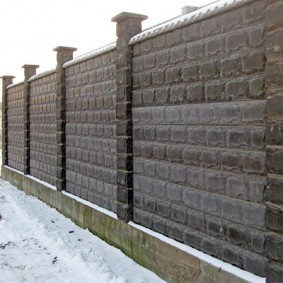 Concrete fence in the winter at the summer cottage