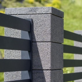 Fastening metal sections of the fence to pillars of blocks