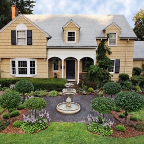 Jardin anglais devant une maison à deux étages