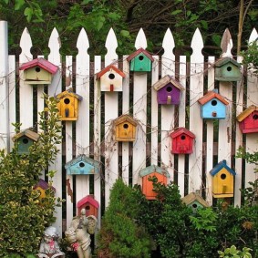 Décoration d'une clôture en bois avec nichoirs faits maison