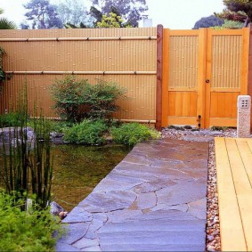 Passerelle en pierre de la maison à la porte en bois