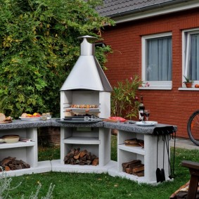 Concrete barbecue on a green lawn