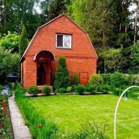 Green lawn in front of a brick house