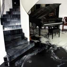 Black grand piano in the hall with stairs