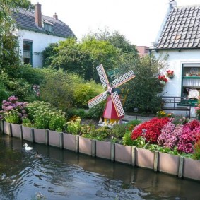 Decorative mill on a plot with a pond