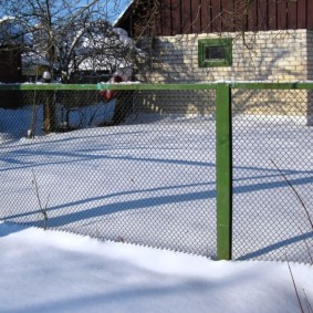 Clôture en maille verte en hiver au chalet