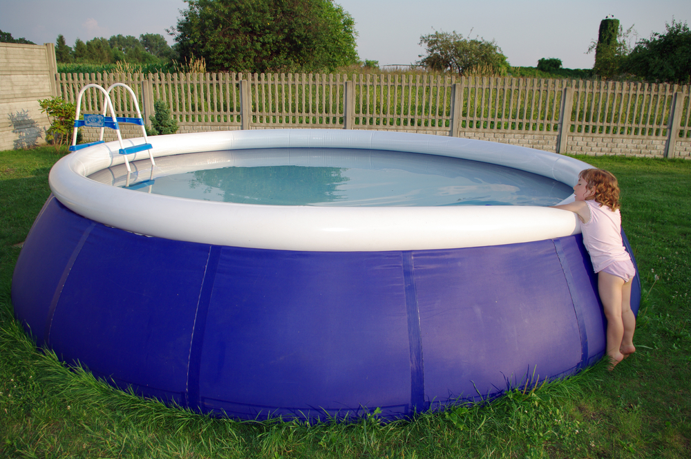 Little child at the side of the inflatable pool