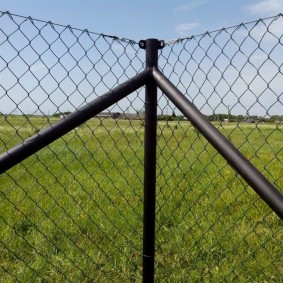 Fixation du filet sur les câbles dans le coin de la clôture