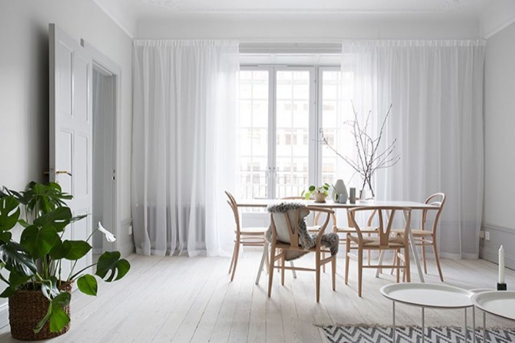 Rideaux de tulle blanc sur une fenêtre de salon de style scandi