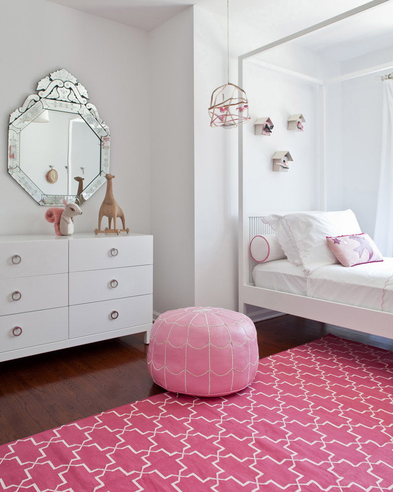 Tapis rose dans une chambre avec une commode blanche