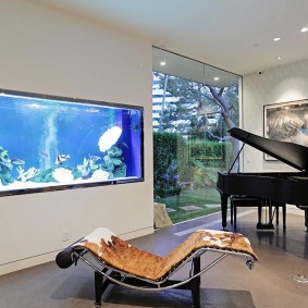 Aquarium intégré dans la chambre avec un piano noir