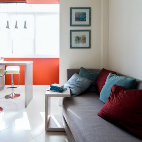 Gray sofa along the white wall of the kitchen