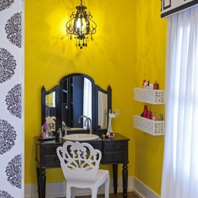 Coiffeuse noire sur fond de mur jaune