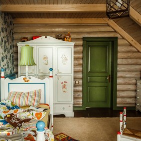 Armoire blanche dans la chambre des enfants de la maison en rondins