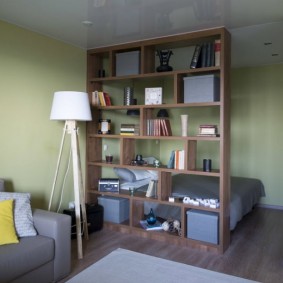 Wooden shelving in front of a sleeping bed