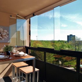 Table à manger sur le balcon avec vitrage sans cadre