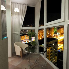 Vista della città di notte da un balcone con porte finestre